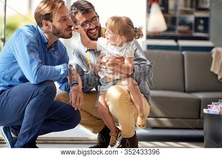 gay parents with child girl in store for household