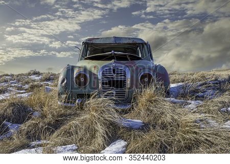 Neidpath, Sk, Canada- Feb. 20, 2020: Abandoned Austin A40 Somerset In The Tall Grass On A Snowy Hill