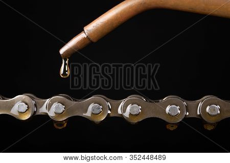 Oiling The Bicycle Chain With An Oiler. Care Of The Bicycle's Drive System.