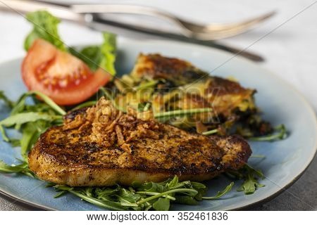 Grilled Pork Steak On Lambs Lettuce On A Plate