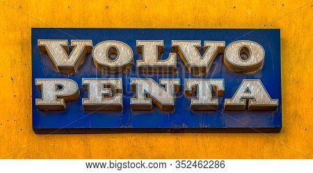 Volvo Penta, A Blue Rectangular Sign With White Letters On A Yelloow Wall, El Gouna, Egypt, January 