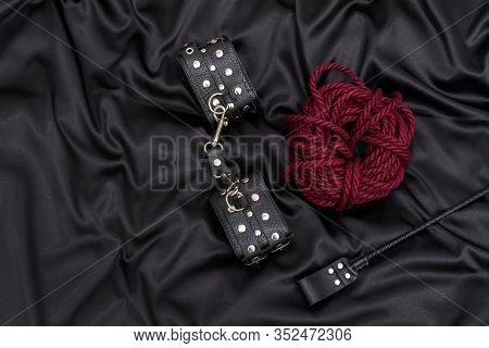 Leather Handcuffs, Shibari Rope And Stack On Black Background