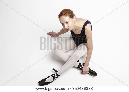 Sport Ideas. Portrait Of Tranquil Caucasian Professional Ballet Dancer In Body Suit  And Pointes Sho