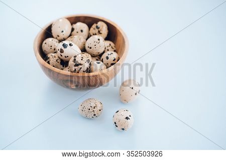 Quail Eggs In Wooden Bowl On A Blue Background. Easter Concept, Flay Lay Photo. Mockup, Space For Te