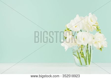 Fresh White Freesia Flowers In Cute Transparent Glass On Soft Light Green Mint Menthe Wall And White