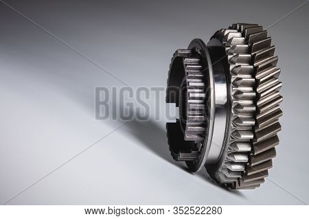 New Parts On A Gray Background. Gears Of Gear Shifting Torque Transmission. Conceptually Mechanical 