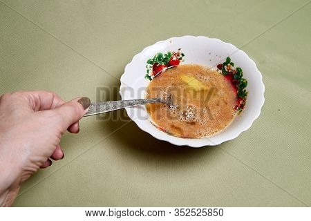 Raw Egg On A White Plate The Table, Small In It And A Spoon In A Womans Handon. Cooking Eggs For Coo