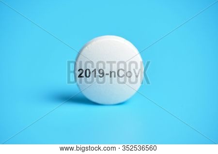 White Tablet On A Blue Background With The Inscription 2019-ncov. Close Up. Panacea Concept.