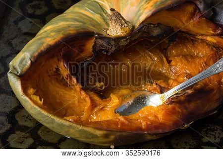Baked Half Of Pumpkin With Spoon In It On The Baking Tray