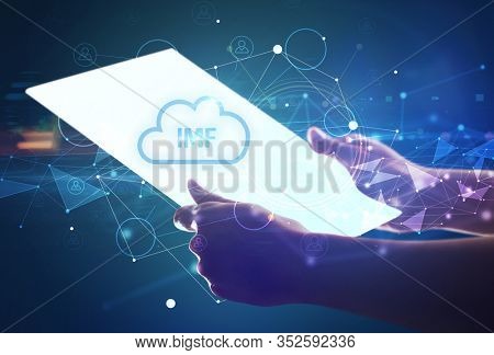 Hand holdig futuristic tablet with IMF inscription, modern technology concept