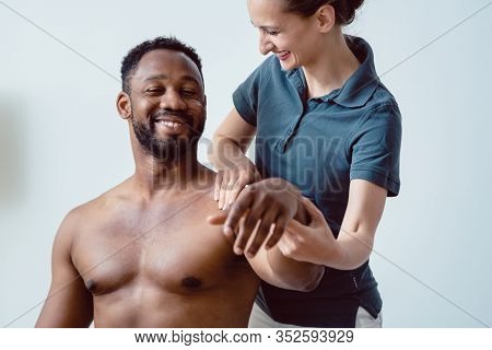 Remobilization of shoulder joint of young man in the physical therapy