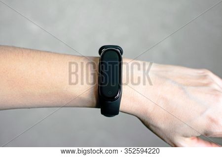 Black Fitness Tracker On A Girls Hand. Fitness Bracelet For Sports Training.