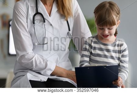 Close-up Of Happy Child With Experienced Pediatrician In Hospital Office. Smiling Little Patient Pai