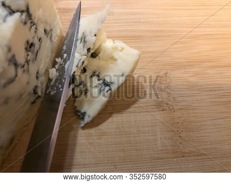 Gorgonzola Cheese Close Up With Copyspace. Knife Cutting Veined Italian Blue Cheese. Mold Made With 