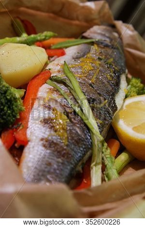Grilled Seabass With Vegetables And Lemon.served On Paper.close Up.