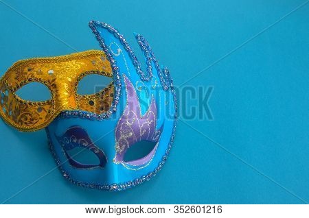 Two Carnival Masquerade Masks Purple And Yellow On A Blue Background Copyspace