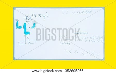 A Seven Year Old Boy Writes And Draws On A Birthday Card For His Grandfather