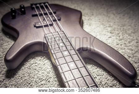 Bass Guitar With Four Strings Closeup. Detail Of Popular Rock Musical Instrument. Close View Of Brow