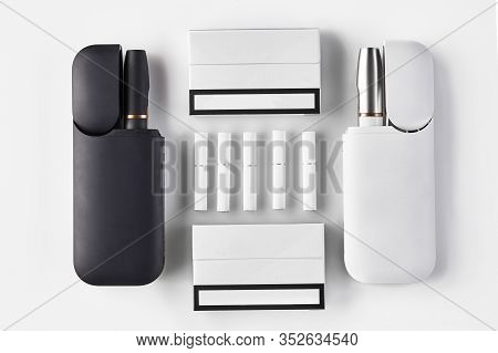 Black And White Electronic Cigarettes In Open Batteries, Two Packs, Five Heatsticks Isolated On Whit
