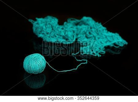 Pile Of Tangled Yarn With A Ball On The End Leading Out. The Concept Of Emerging Order