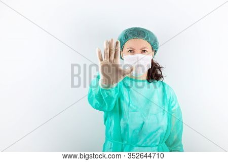 Female Caucasian Race Nurse In Medical Cap, Green Coat, Gloves, Mask On White Background. With Forwa