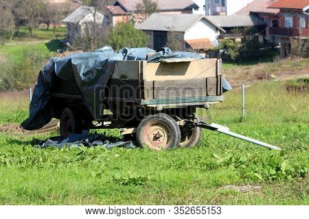 Old Retro Vintage Rustic Dilapidated Tractor Trailer Covered With Thick Dark Nylon For Protection Le