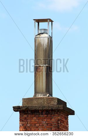 Dirty Old Industrial Chimney With Metal Cap On Top Made Of Partially Rusted Thin Metal On Top Of Red