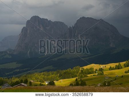 Sassolungo Mountains On The Italian Alps Dolomites On The Shadow With The Sunlight Appearing On The 