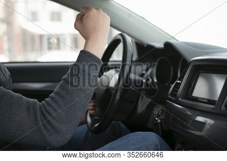 Angry Driver Is Shaking His Fist By Sitting By Steering Wheel Close Up.