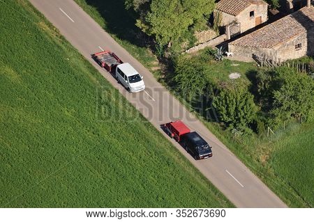 Aerial View Of Two White And Black Vans Carrying A Trailer For A Hot-air Balloon Basket In A Beautif