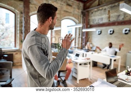 I Quit. Young Man In Casual Wear Holding Box With Personal Things And Saying Good Bye To His Ex-coll