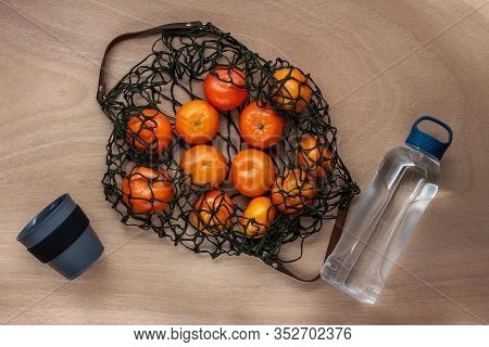 Mandarins, Pomelo, Pomegranate In Green Net Bag Zero Waste Concept Lay On Wooden Table