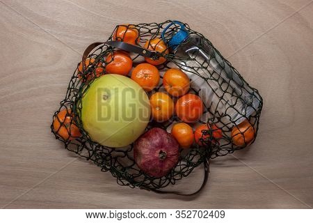 Mandarins, Pomelo, Pomegranate In Green Net Bag Zero Waste Concept Lay On Wooden Table