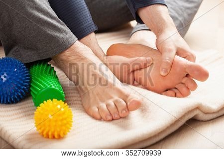 man doing flatfoot correction self massage at home