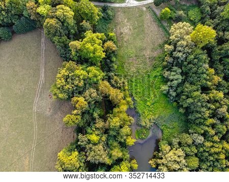 Aerial View Of Forest And Small Lake During Autumn Season And Colors. Countryside Of Walloon Brabant