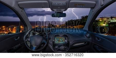 Looking Through A Car Windshield With View Over Lightning Storm Over The Sea