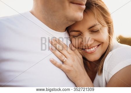 Lovely Caucasian Woman Lying On Her Husband And Embracing Him During A Perfect Sunshine