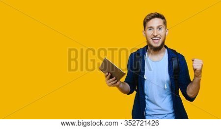 Caucasian Student With Red Hair Nd Nice Beard Is Holding A Tablet And Wearing A School Bag While Ges