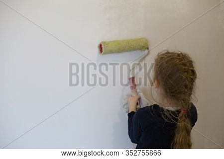 Child Stands With His Back And Painstakingly Paints The Walls Of The House In White