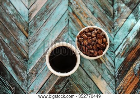 Specialty Concept. Black Coffee And Roasted Beans In Two White Cups On Turquoise Wooden Parquet Back