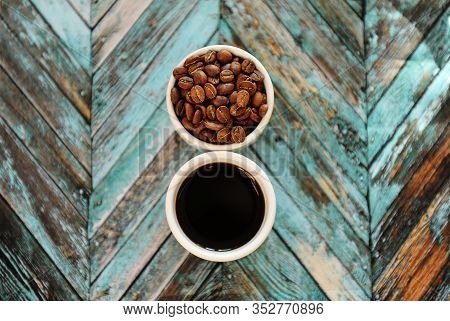 Specialty Concept. Black Coffee And Roasted Beans In Two White Cups On Turquoise Wooden Parquet Back