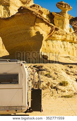 Camper Car On Parking Area At Eroded Yellow Sandstone Formations, Enchanted City Of Bolnuevo, Murcia