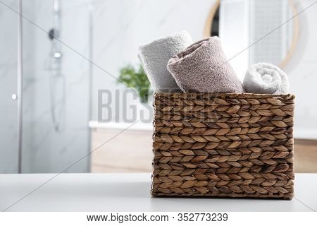 Wicker Basket With Clean Soft Towels In Bathroom. Space For Text