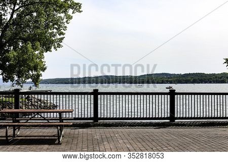 View From The Pedestrian Bridge Of Canandaigua Lake. Brick Bridge With A Picnic Table. Canandaigua N