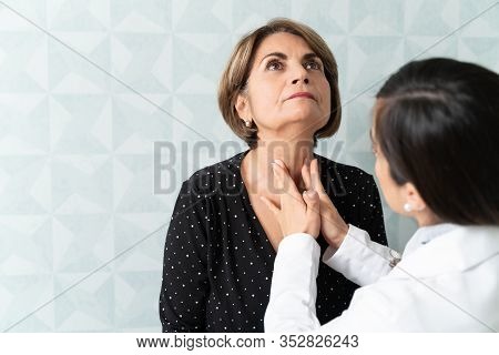 Caucasian Woman Visiting Female Geriatrician For Thyroid Checkup