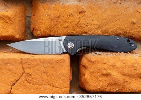 Knife In The Brick Wall. Red Brick Wall. Background Of Bricks.
