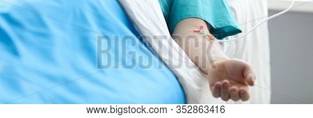 Fight For Life Concept. Hand Of A Young Man With A Dropper In Ward Of Medical Hospital. Lies After C