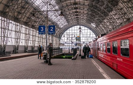 Moscow, Russia - March 23, 2013: Covered platform of Kievsky railway station. Red train aeroexpress to airport. People on the platform beside the Aero express train at Kievsky railway station Moscow