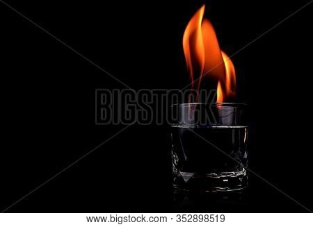 Glass With Vodca And Fire Flame On Black Background