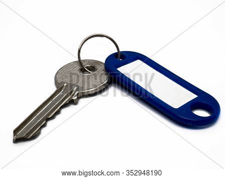 Single Key And A Blue Key Ring With Tag On White Background.